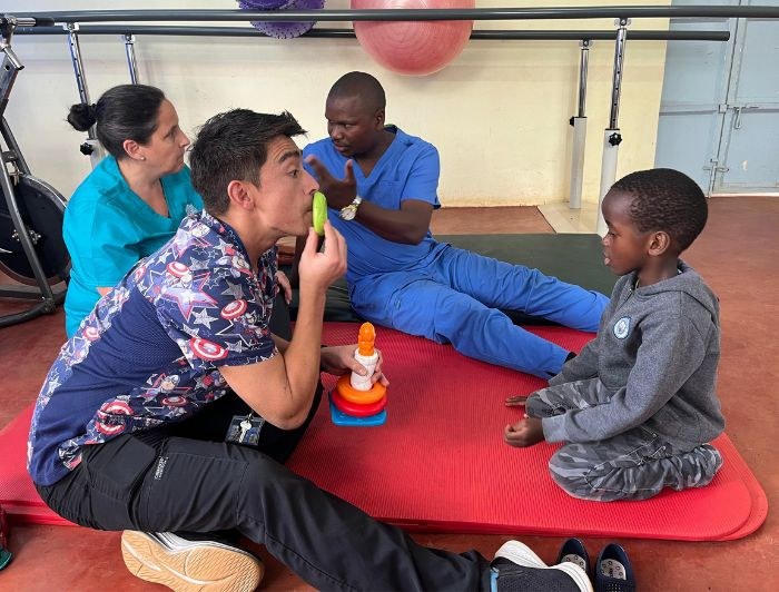 A UC Chile therapy team working with a child at the centre