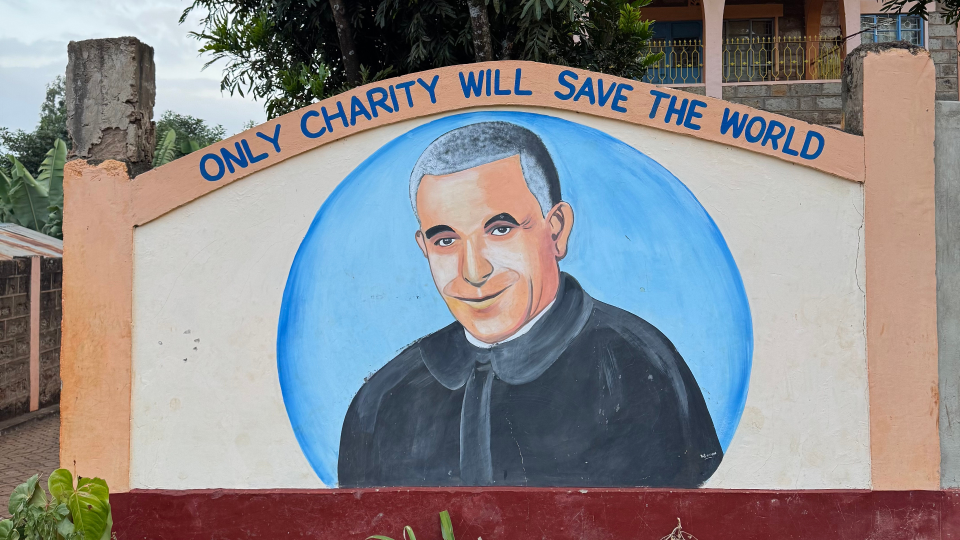 Mural of Saint Luigi Orione with the words Only charity will save the world