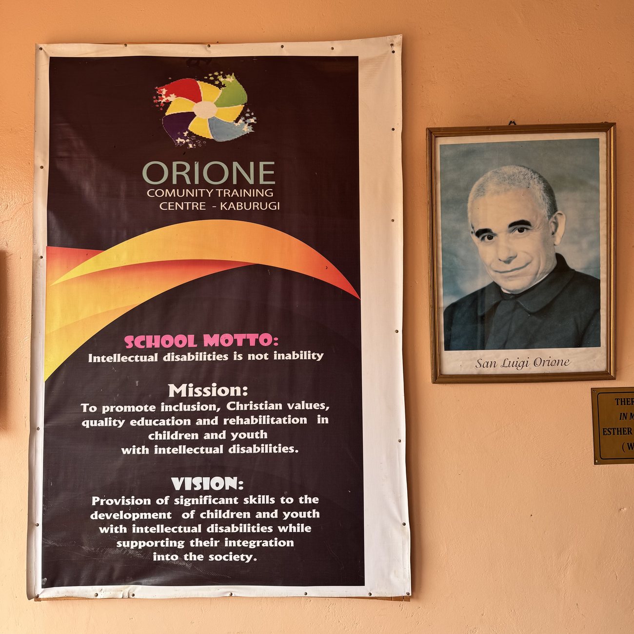 The centre's mission and vision banner beside a portrait of Saint Luigi Orione