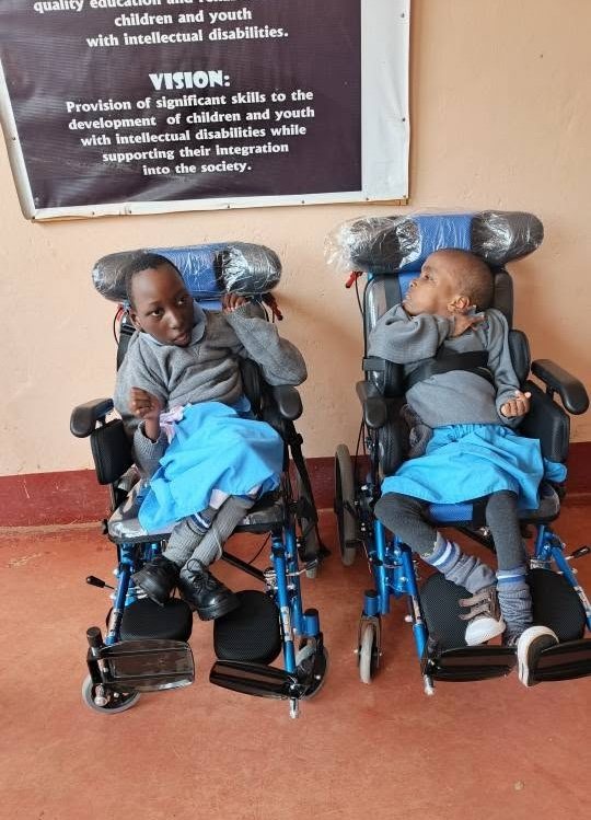 Two children in brand new wheelchairs at the centre