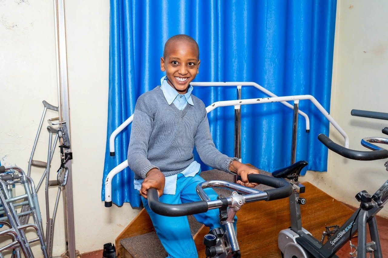 A smiling child exercising in the therapy room